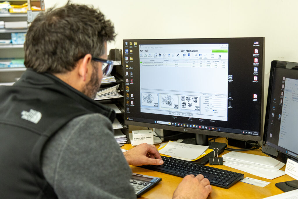Capitol Copy designer laying out a print project